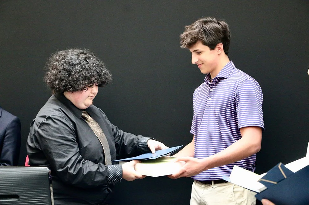 Natty Gove presents a laptop to a recipient at the SFUSD awards ceremony